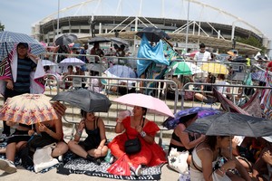 People holding umbrellas wait for the Taylor Swift concert, following the death of a fan due to the heat during the first day concert, in Rio de Janeiro, Brazil, November 18, 2023. REUTERS/Pilar Olivares