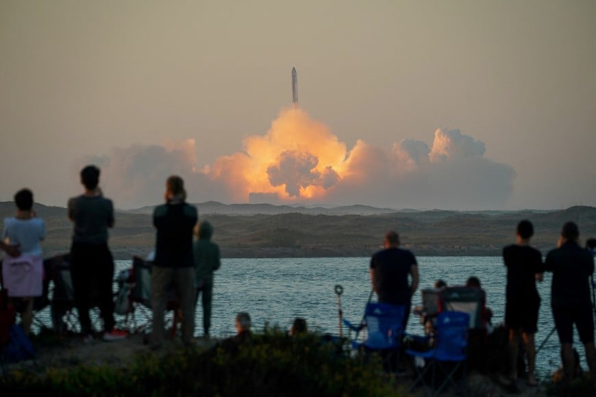 People watch as SpaceX's next-generation Starship spacecraft atop its powerful Super Heavy rocket lifts off from the company's Boca Chica launchpad on an uncrewed test flight, as seen from South Padre Island, near Brownsville, Texas, U.S. November 18, 2023. REUTERS/Go Nakamura     TPX IMAGES OF THE DAY