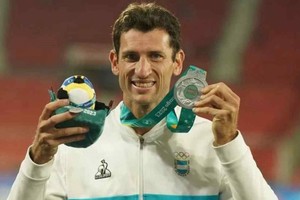 Germán Chiaraviglio posando con la medalla de plata y su muñeco de los Panamericanos de Santiago 2023. Créditos: @gerchiara