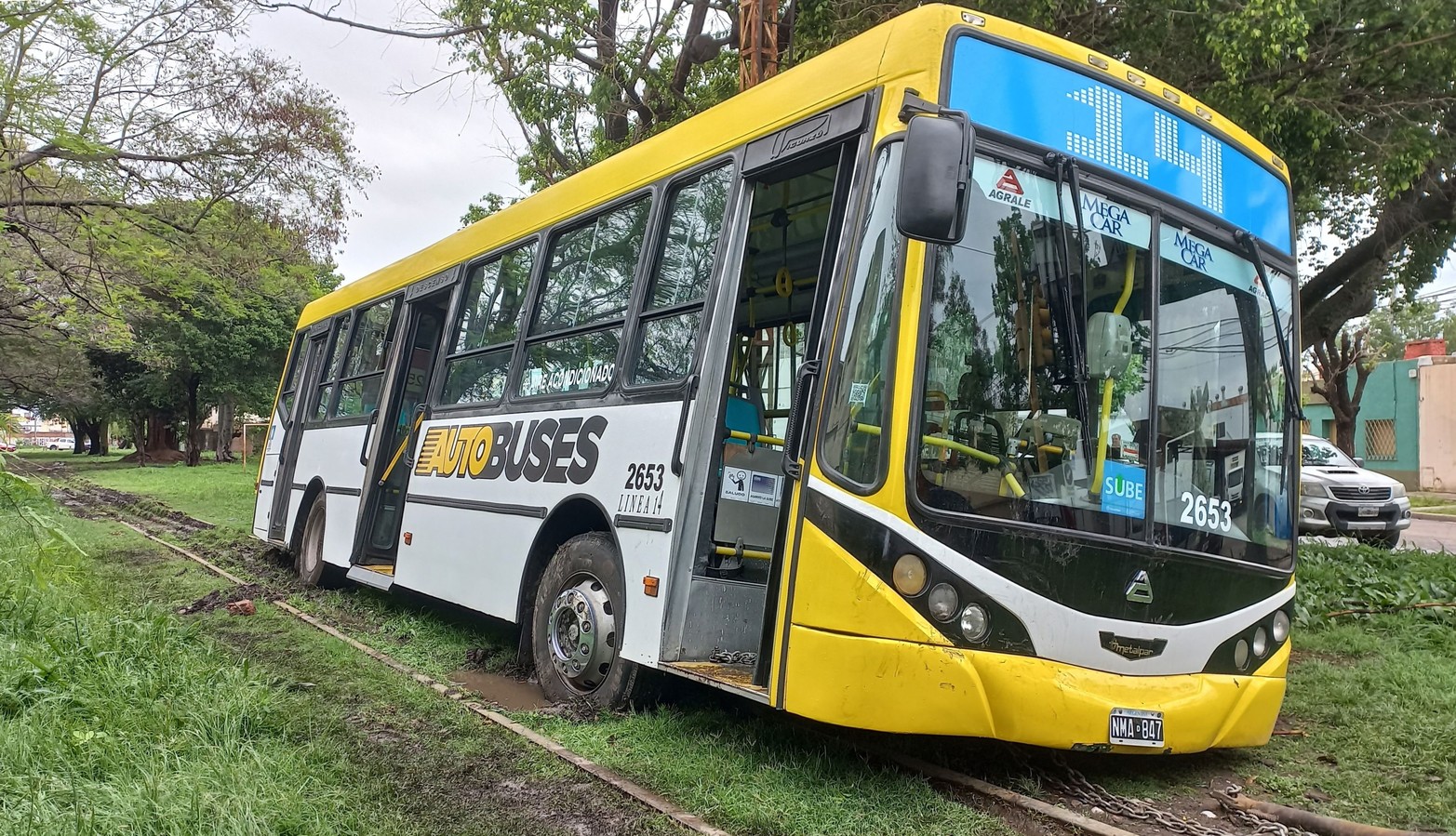 En la vía enterrado en barro . Un colectivo de la Linea 14 quedó atascado cuando realizó una maniobra en la que circuló casi 100 metros por las vías del tren en plena tormenta