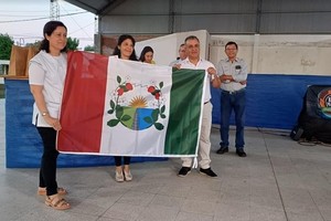 La Directora de la escuela ganadora y el presidente comunal sostienen con orgullo la bandera de ceremonias. Fotos: Comuna de Desvío Arijón.