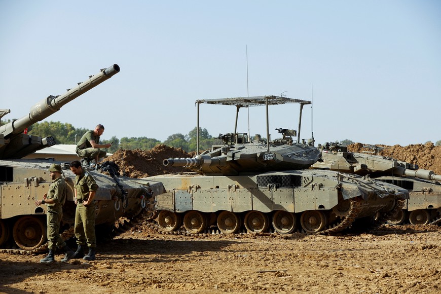 Israeli soldiers stand next to a Merkava tank near the Israel-Gaza border, amid the ongoing conflict between Israel and the Palestinian group Hamas, Israel November 23, 2023. REUTERS/Alexander Ermochenko
