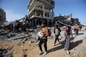Displaced Palestinians return to their homes as they walk near houses destroyed in an Israeli strike during the conflict, amid the temporary truce between Hamas and Israel, in Khan Younis in the southern Gaza Strip November 24, 2023. REUTERS/Ibraheem Abu Mustafa