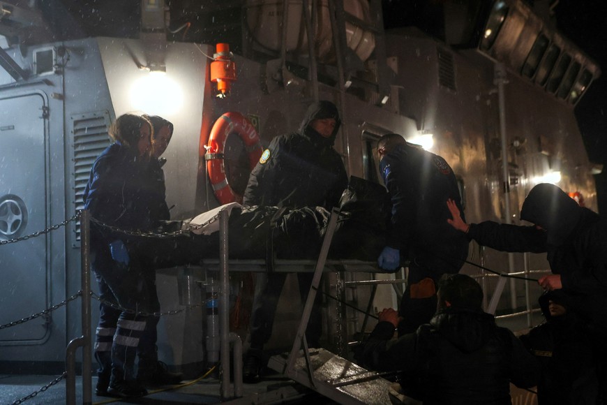 Hellenic Coast Guard officers and medical personnel carry the body of a crew member of a cargo ship following a rescue operation, after the vessel sank off the island of Lesbos, Greece, November 26, 2023. REUTERS/Elias Marcou