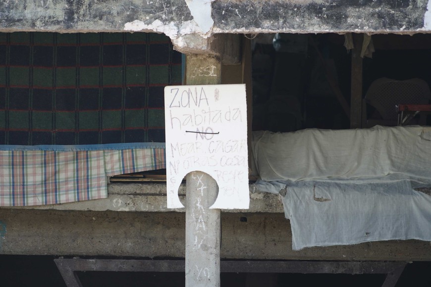 El cartel con el llamativo mensaje. Detrás, sábanas, frazadas y colchones. Foto: Fernando Nicola