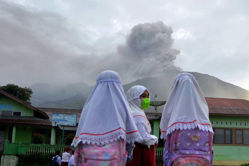 Students are seen at school as Mount Marapi volcano spews volcanic ash as seen from Nagari Batu Palano in Agam, West Sumatra province, Indonesia, December 4, 2023, in this photo taken by Antara Foto. Antara Foto/Iggoy el Fitra/via REUTERS ATTENTION EDITORS - THIS IMAGE HAS BEEN SUPPLIED BY A THIRD PARTY. MANDATORY CREDIT. INDONESIA OUT. NO COMMERCIAL OR EDITORIAL SALES IN INDONESIA.     TPX IMAGES OF THE DAY