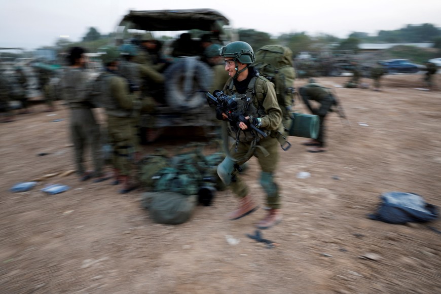 An Israeli soldier walks with a weapon, amid the ongoing conflict between Israel and the Palestinian Islamist group Hamas, near Israel's border with Gaza, in southern Israel, December 4, 2023. REUTERS/Amir Cohen