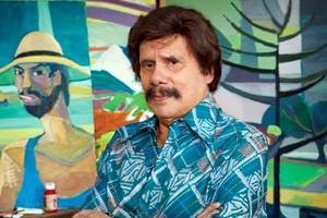 Ayala entre sus pinturas, retratado por el fotógrafo santafesino Marcos López, quien también realizó un documental sobre el personaje. Foto: Télam