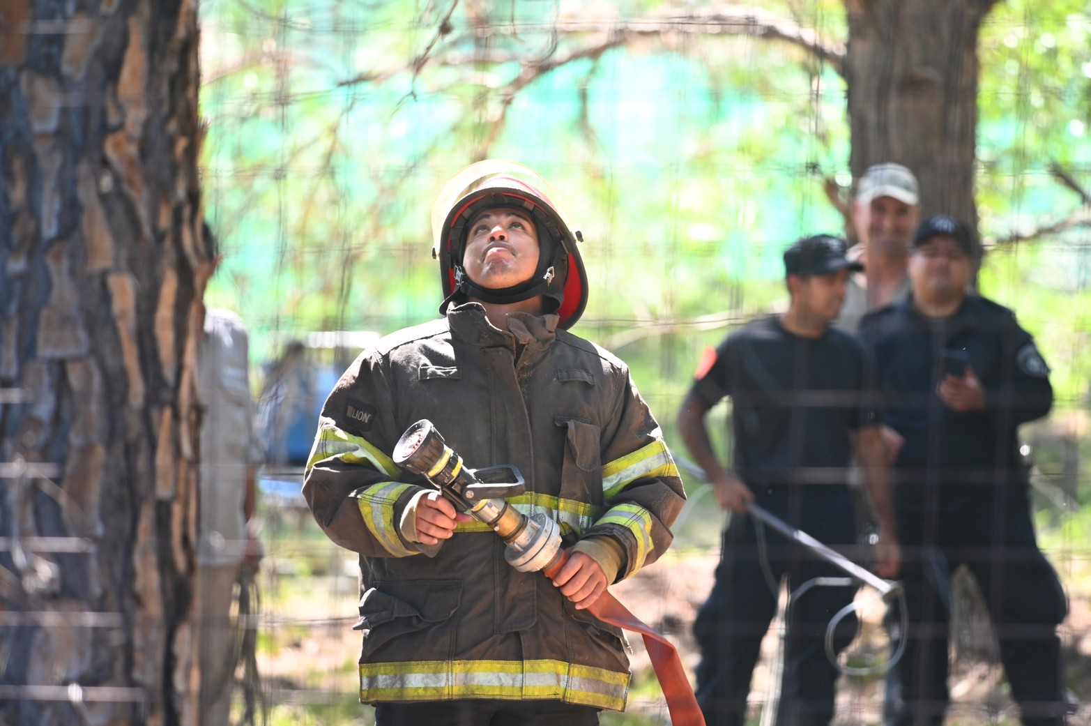 ¿Llegará el agua? Un bombero mire hacia arriba calculando la altura. Foto Mauricio Garín