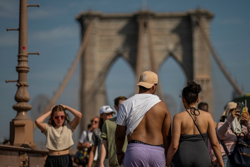 People visit the Brooklyn Bridge during hot weather in New York City, U.S., July 13, 2023. REUTERS/Eduardo Munoz