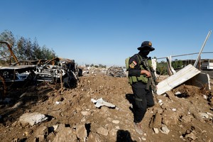 A fighter of the Iraqi Kataib Hezbollah militia group inspects the site of a U.S. airstrike, in Hilla, Iraq December 26, 2023. REUTERS/Alaa al-Marjani
