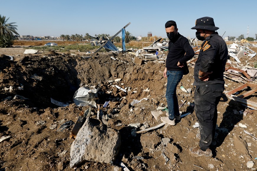 A fighter of the Iraqi Kataib Hezbollah militia group and a man inspect the site of a U.S. airstrike, in Hilla, Iraq December 26, 2023. REUTERS/Alaa al-Marjani