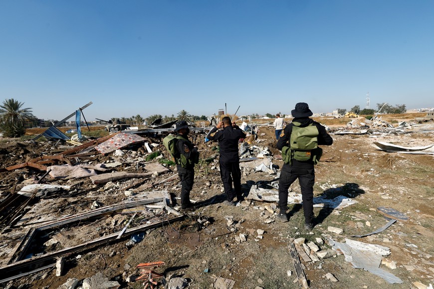 Fighters of the Iraqi Kataib Hezbollah militia group and a man inspect the site of a U.S. airstrike, in Hilla, Iraq December 26, 2023. REUTERS/Alaa al-Marjani