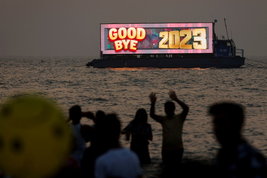 People watch the last sunset of the year from a beach on New Year's eve in Mumbai, India, December 31, 2023. REUTERS/Francis Mascarenhas