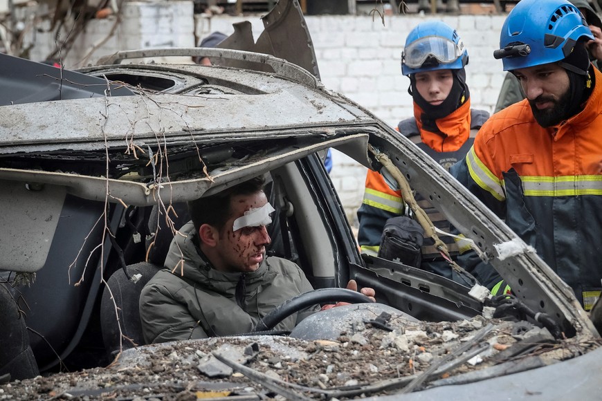 Rescuers speak with a wounded local resident at the site where a residential building was heavily damaged during a Russian missile attack, amid Russia's attack on Ukraine, in central Kharkiv, Ukraine January 2, 2024. REUTERS/Vyacheslav Madiyevskyy     TPX IMAGES OF THE DAY