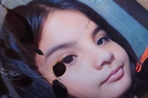 Viste remera marrón, pantalón corto negro, zapatillas negras y blancas.