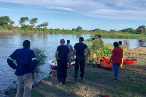 Policías y bomberos voluntarios buscan el cuerpo del adolescente. Crédito: El Litoral.