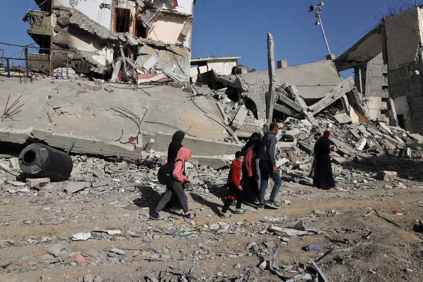 (240110) -- GAZA, 10 enero, 2024 (Xinhua) -- Personas caminan frente a edificios destruidos, en la Ciudad de Gaza, el 10 de enero de 2024. Al menos 147 palestinos han muerto en las últimas 24 horas en los ataques israelíes a lo largo de la Franja de Gaza, lo que elevó el número de víctimas mortales en el enclave a 23.357 desde el inicio del actual conflicto el 7 de octubre de 2023, informó el miércoles el Ministerio de Salud con sede en Gaza. (Xinhua/Mohammed Ali) (ah) (ra) (vf)