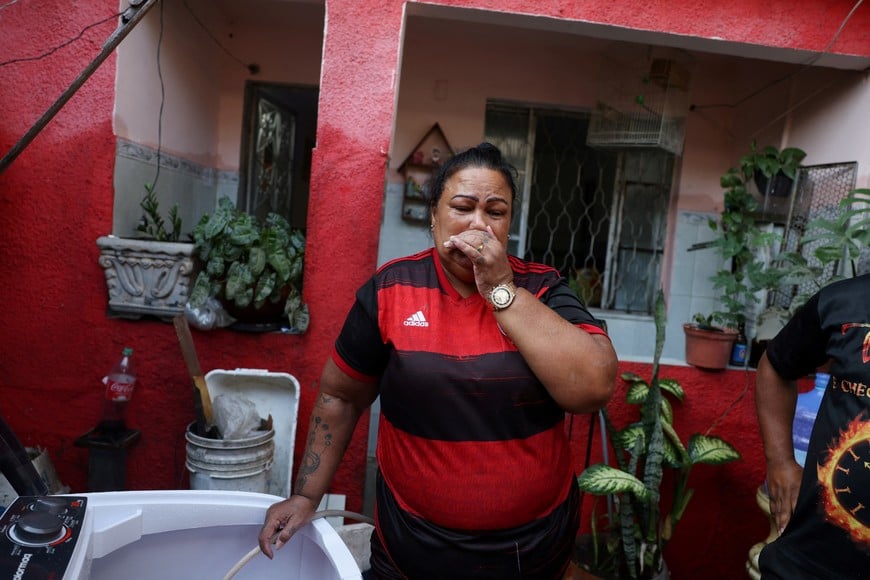 Renata de Oliveira, 57, cries after she lost her belongings after heavy rains hit Rio de Janeiro, in Acari slums complex, Rio de Janeiro, Brazil, January 14, 2024. REUTERS/Pilar Olivares