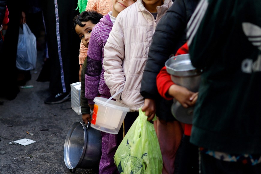 Palestinians wait to receive food cooked by a charity kitchen amid shortages of food supplies, amid the ongoing conflict between Israel and the Palestinian Islamist group Hamas, in Rafah in the southern Gaza Strip, January 16, 2024. REUTERS/Ibraheem Abu Mustafa