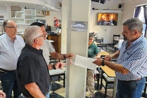 Larriera hijo y el intendente Ramírez descubren la placa en el ex bar Mosconi de Coronda. Crédito: Coronda Registrada.