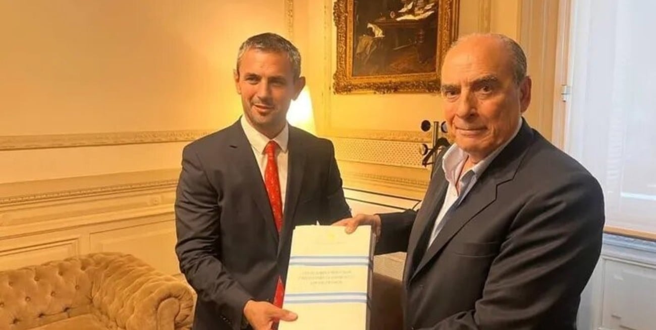 Martín Menem y Guillermo Francos exhibiendo el texto original de la ley ómnibus.