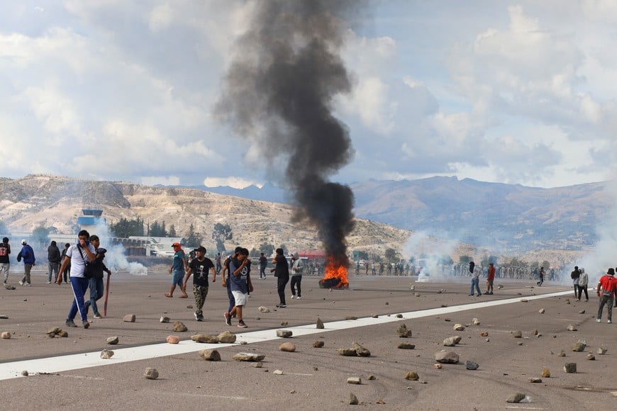 Demonstrators stand on an airport tarmac amid violent protests following the ouster of former Peruvian President Pedro Castillo, in Ayacucho, Peru December 15, 2022. REUTERS/Miguel Gutierrez Chero NO RESALES. NO ARCHIVES