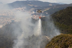 Uno de los incendios afectó los imponentes cerros orientales de Bogotá, siendo visible el humo -esparcido por el viento- desde varios sectores de la capital de Colombia. En la imagen, un helicóptero descarga agua sobre dichas colinas. Reuters / Antonio Cascio