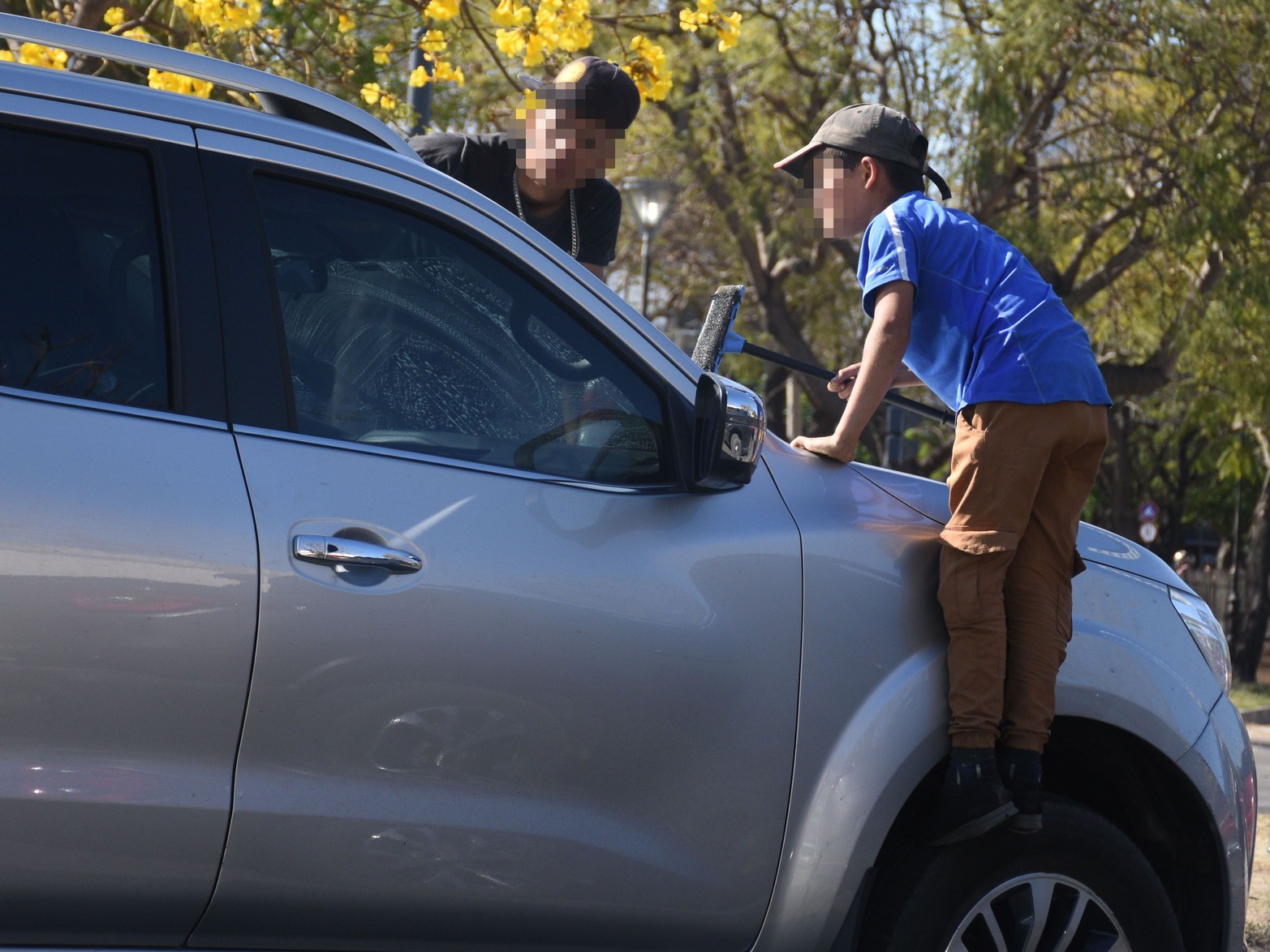 Niños limpiando vidrios en avenida Alem.