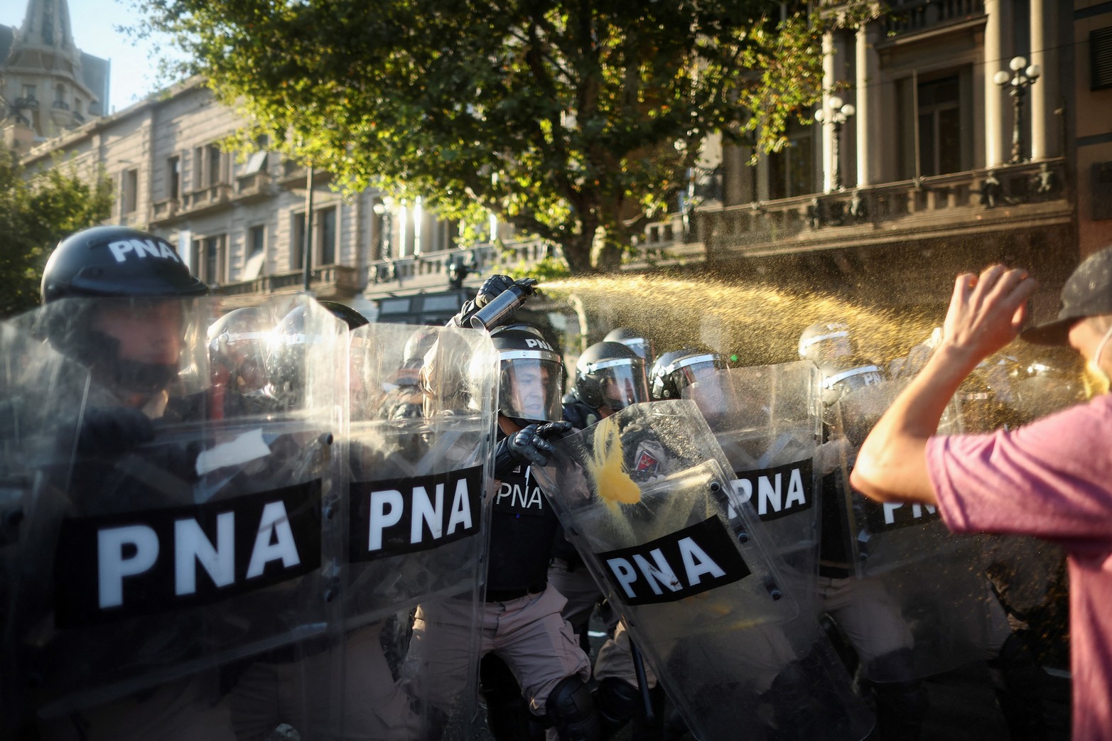 Agentes encargados de hacer cumplir la ley rocían a manifestantes mientras protestan frente al Congreso Nacional.