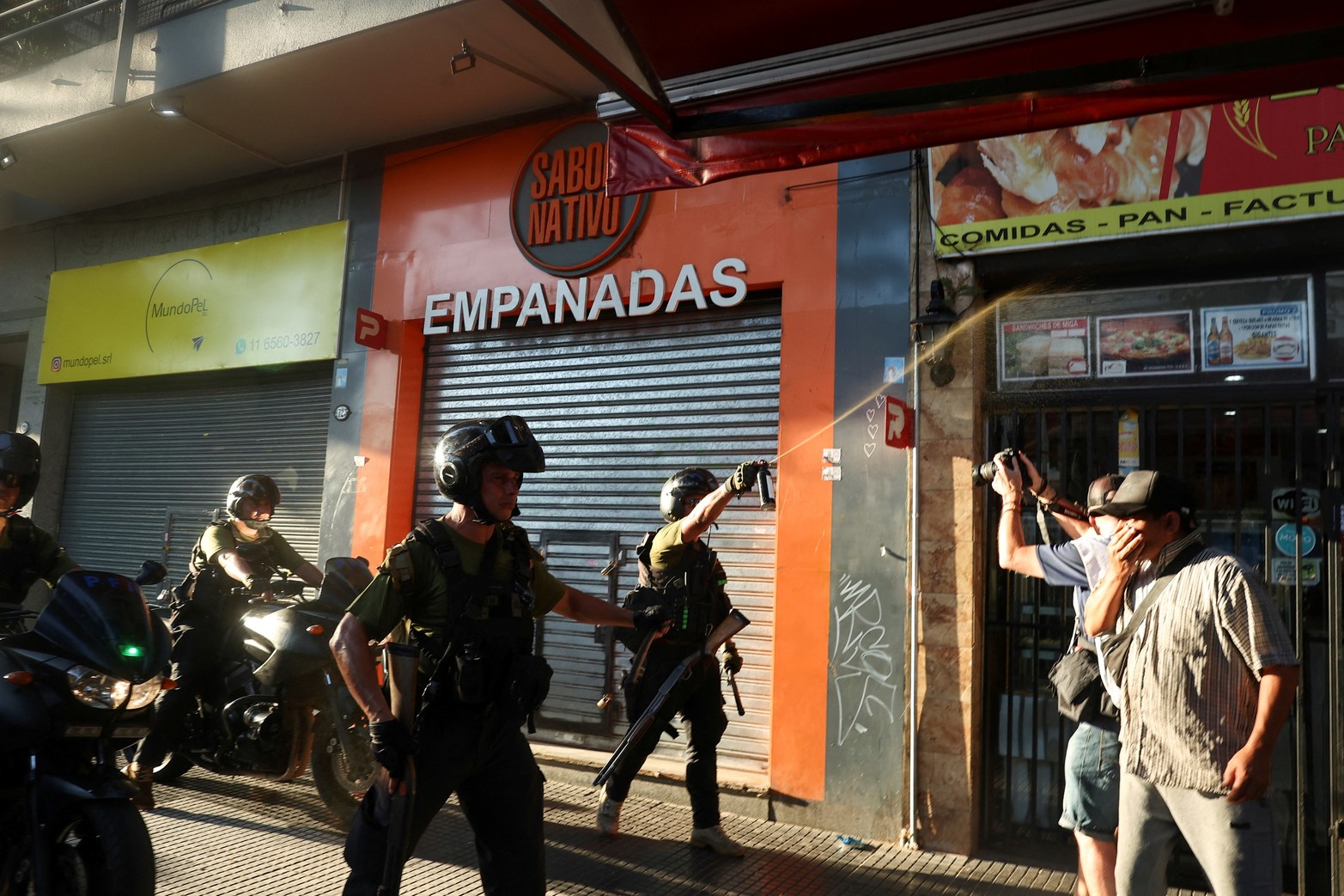 Agentes encargados de hacer cumplir la ley rocían a manifestantes mientras protestan frente al Congreso Nacional.