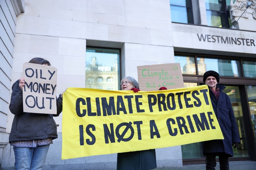 Climate change protesters hold signs outside Westminster Magistrates' Court, on the day of Greta Thunberg's trial in London, Britain, February 1, 2024. REUTERS/Isabel Infantes
