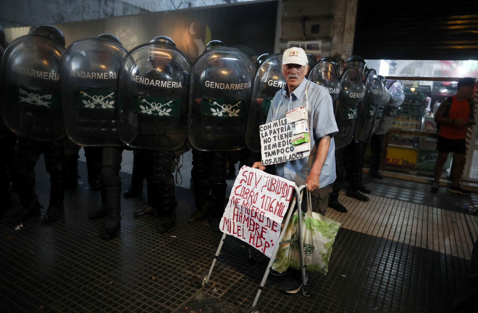 Un hombre jubilado con su andador en la zona del Congreso y con el cartel que dice que su jubilación es de 106.000 pesos. 