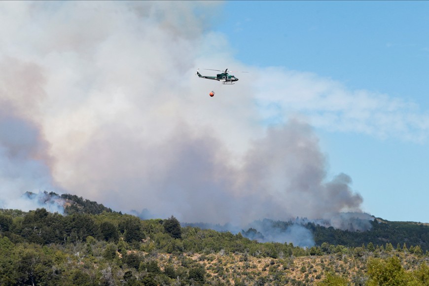 A helicopter flies with water to put out a wildfire at Los Alerces National Park, in Chubut, Argentina January 28, 2024. REUTERS/Martin Levicoy NO RESALES. NO ARCHIVES