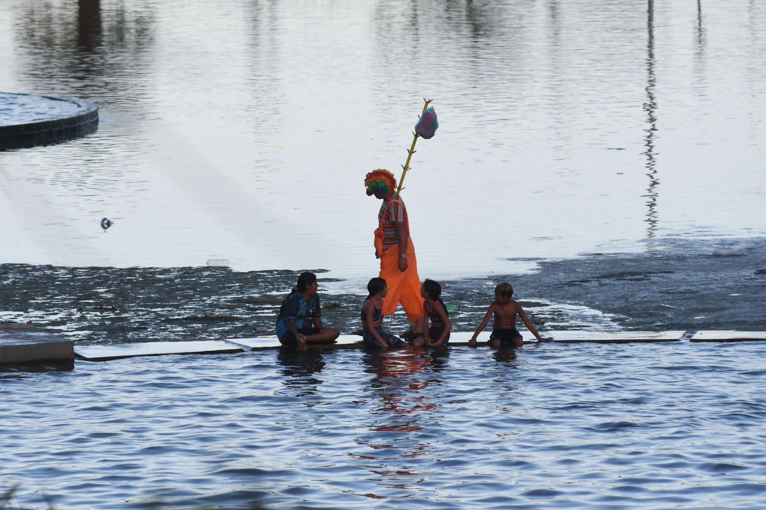 Un payaso se lleva las miradas de los niños en los piletones del Parque del Sur.