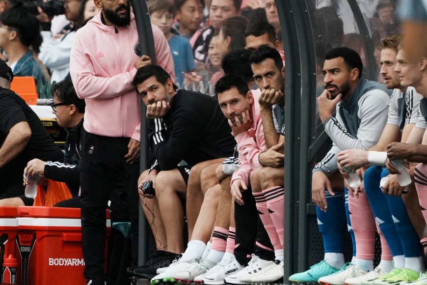 Soccer Football - Friendly - Hong Kong v Inter Miami - Hong Kong Stadium, Hong Kong - February 4, 2024
Inter Miami's Lionel Messi, Sergio Busquets and teammates sit on the substitute bench during the match as Lionel Messi security guard Yassine Cheuko looks on
REUTERS/Lam Yik