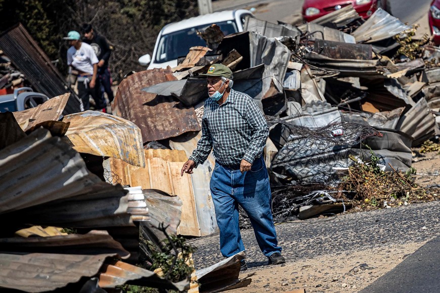 (240205) -- VIÑA DEL MAR, 5 febrero, 2024 (Xinhua) -- Una persona camina frente a los escombros de casas destruidas por un incendio forestal, en Viña del Mar, Chile, el 5 de febrero de 2024. El número de las personas fallecidas por los incendios forestales que afectan a la región chilena de Valparaíso, en la zona central del país sudamericano, aumentó a 122, informó el lunes el Gobierno de Chile. (Xinhua/Str) (jv) (rtg) (ah) (vf)