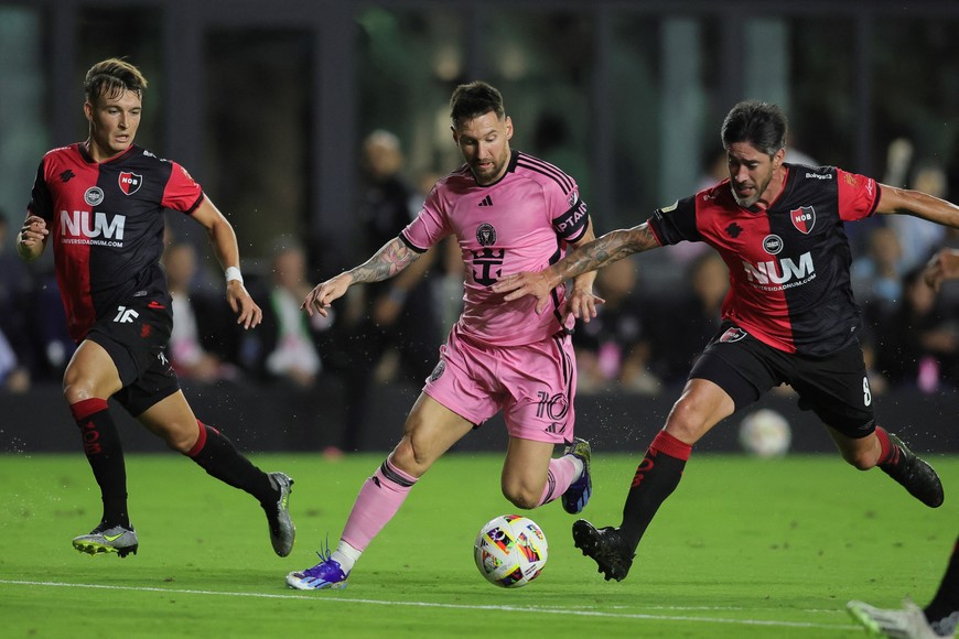 Feb 15, 2024; Fort Lauderdale, FL, USA; Inter Miami CF forward Lionel Messi (10) dribbles the ball past Newell's Old Boys defender Pablo Perez (8) during the first half at DRV PNK Stadium. Mandatory Credit: Sam Navarro-USA TODAY Sports