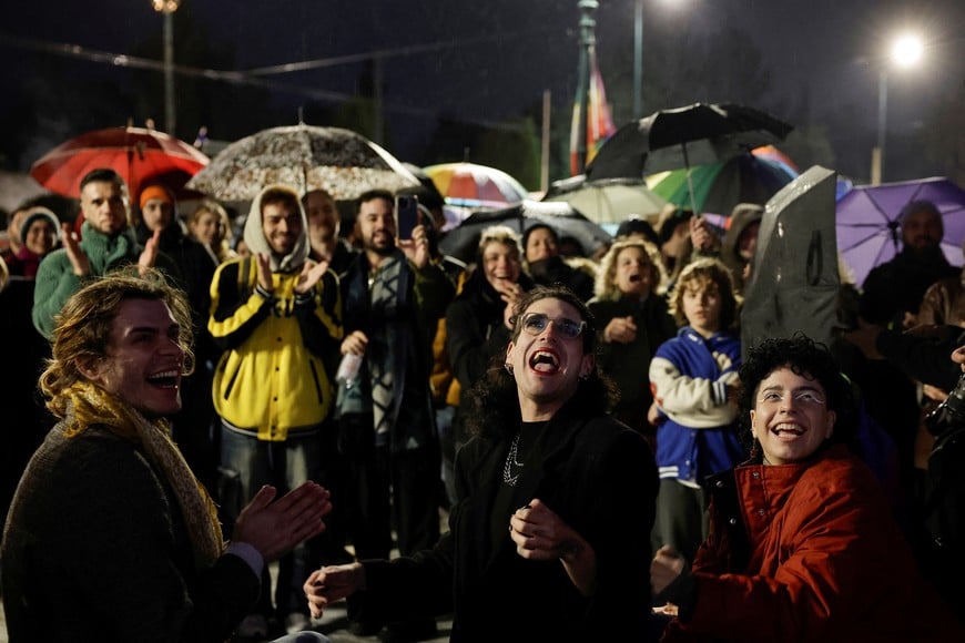 Members of the LGBTQ+ community and supporters watch the end of debate in front of the Greek parliament, ahead of the vote on the bill which legalises same-sex civil marriage, in Athens, Greece, February 15, 2024.  REUTERS/Louisa Gouliamaki