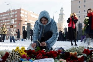 Una mujer deposita flores en el monumento a las víctimas de la represión política en Moscú, tras la muerte del líder de la oposición rusa Alexei Navalny. Foto: Reuters