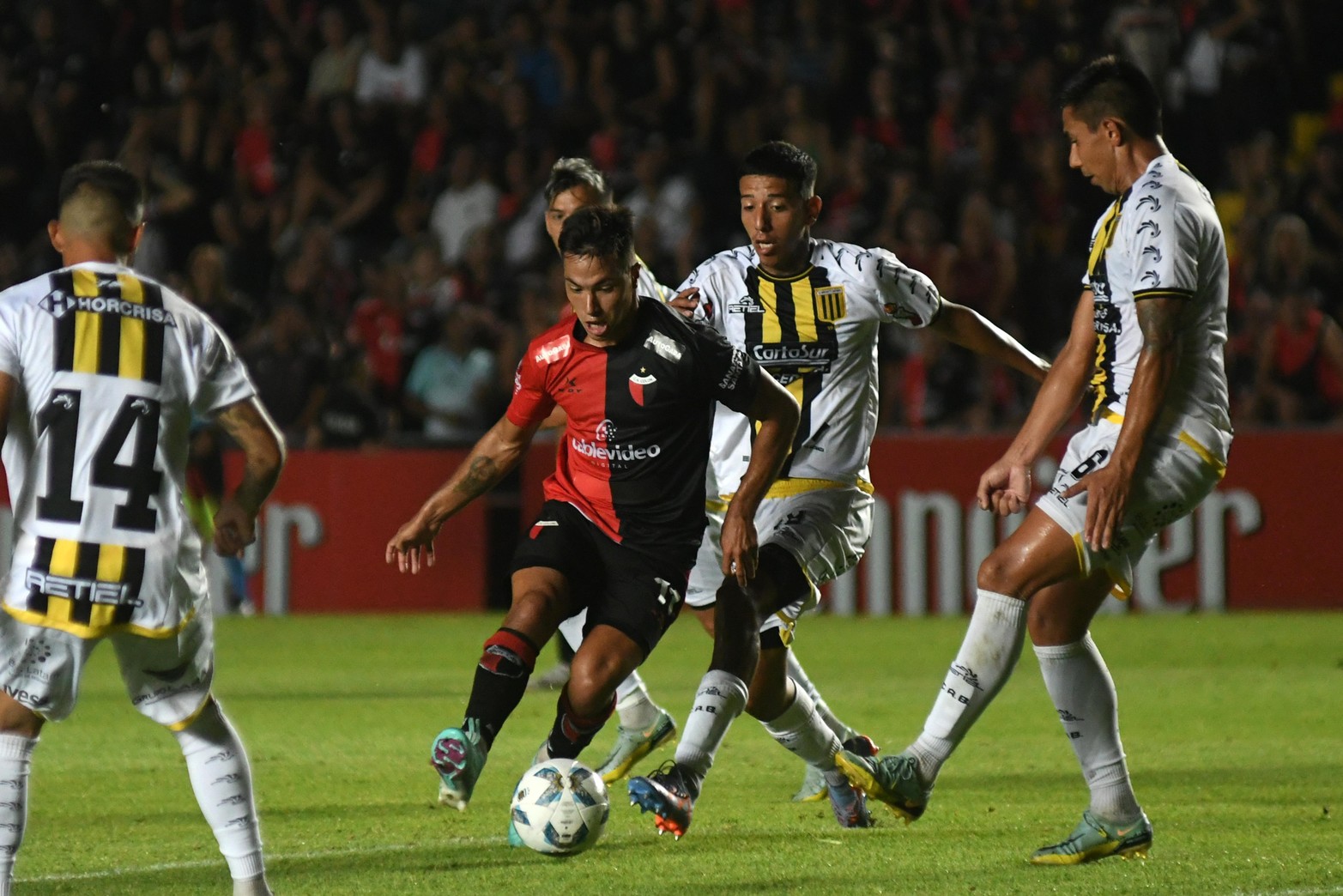 Ignacio Lago entre tres rivales. Colón volvió a ganar de local. Por la tercera fecha de la Primera B Nacional venció a Almirante Brown por 2 a 1.