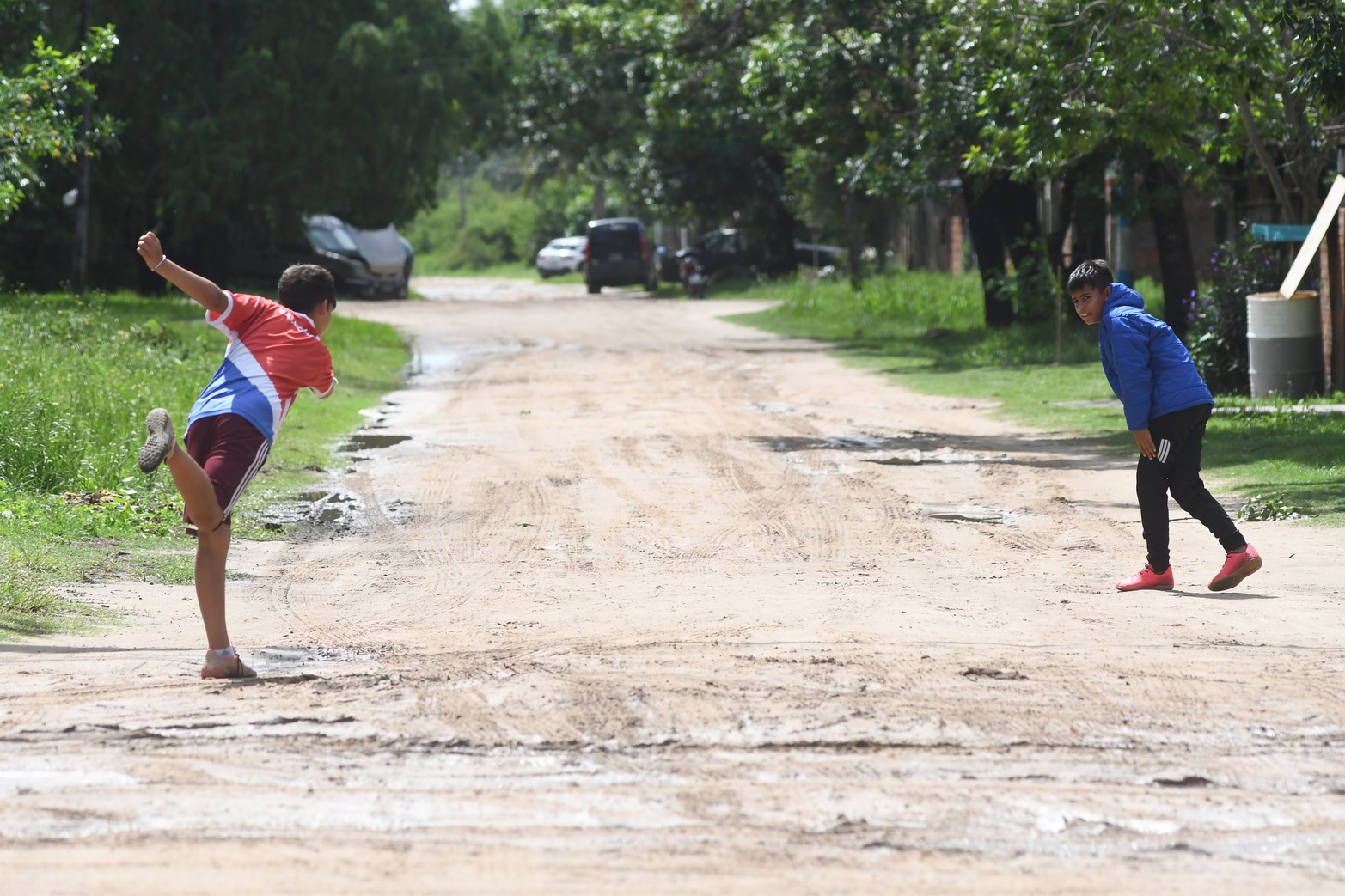 Jugando a la bolita. En La Guardia, en una calle de arena dos niños juegan en un improvisado hoyo.