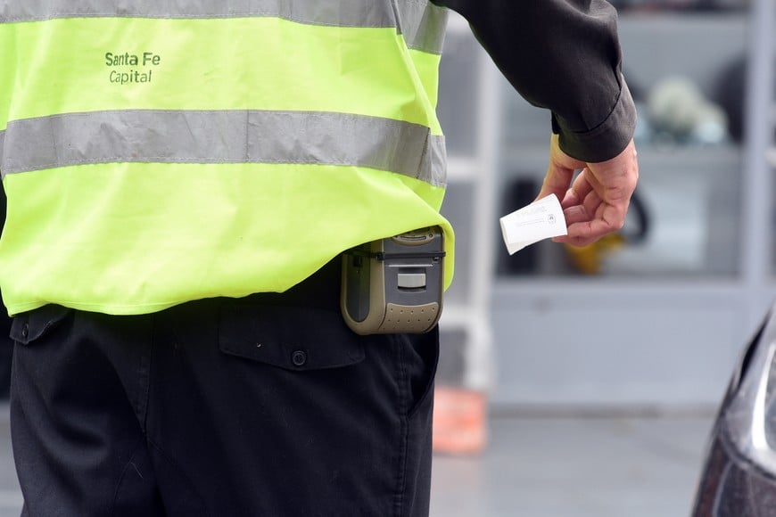 Un inspector municipal, labrando una multa de tránsito. Hoy, la contravención por cruzar en el semáforo en rojo cuesta hasta 1,2 millones de pesos.