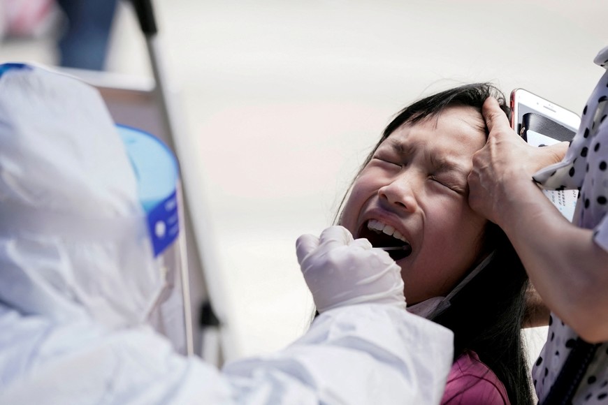 FILE PHOTO: A child reacts while undergoing nucleic acid testing in Wuhan, the Chinese city hit hardest by the coronavirus disease (COVID-19) outbreak, Hubei province, China May 16, 2020. REUTERS/Aly Song/File Photo