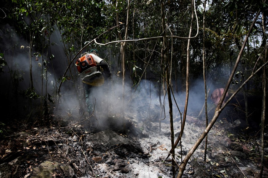 Brazilian Institute for the Environment and Renewable Natural Resources (IBAMA) fire brigade member attempts to control fire in the Malacacheta mountain range, in the Tabalascada Indigenous Land, located in the municipality of Canta, Roraima, Brazil February 28, 2024. REUTERS/Bruno Kelly