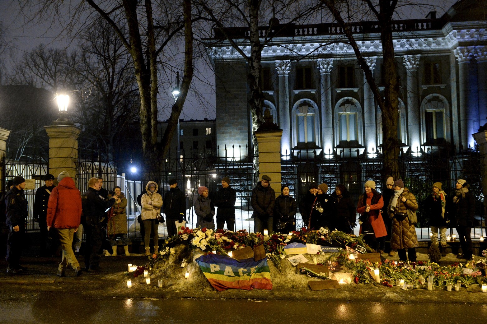 La gente se reúne junto a tributos florales durante una manifestación frente a la embajada rusa el día del entierro del líder de la oposición rusa Alexei Navalny, en Helsinki, Finlandia, el 1 de marzo de 2024. 