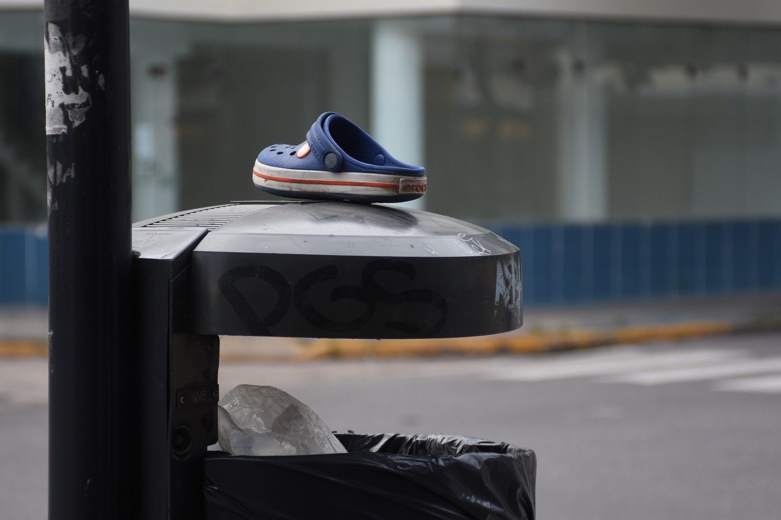 En las paradas de colectivos suelen aparecer objetos domésticos. Un usuario con buen tino dejó el calzado de un niño sobre un cesto de basura.