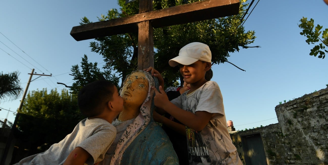 Postales de barrio. A los chicos les llama la atención la estatua de la virgen que está frente a la vecinal. Crédito: Manuel Fabatía