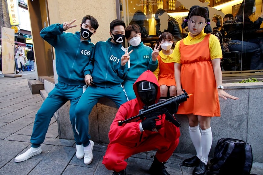 People wearing Netflix series 'Squid Game' costumes pose for photographs on the street in downtown Seoul, South Korea, October 30, 2021.  REUTERS/ Heo Ran