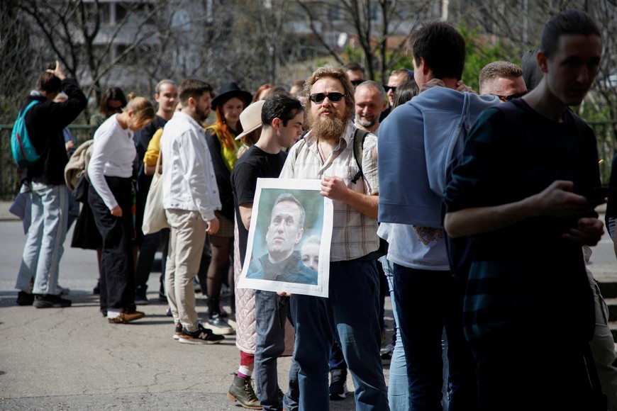 A man holds a placard with a photo of late Russian opposition leader Alexei Navalny while he waits in line in front of the Russian embassy to vote on the last day of presidential elections, where Vladimir Putin is seeking another six-year term in Podgorica, Montenegro, March 17, 2024. REUTERS/Stevo Vasiljevic